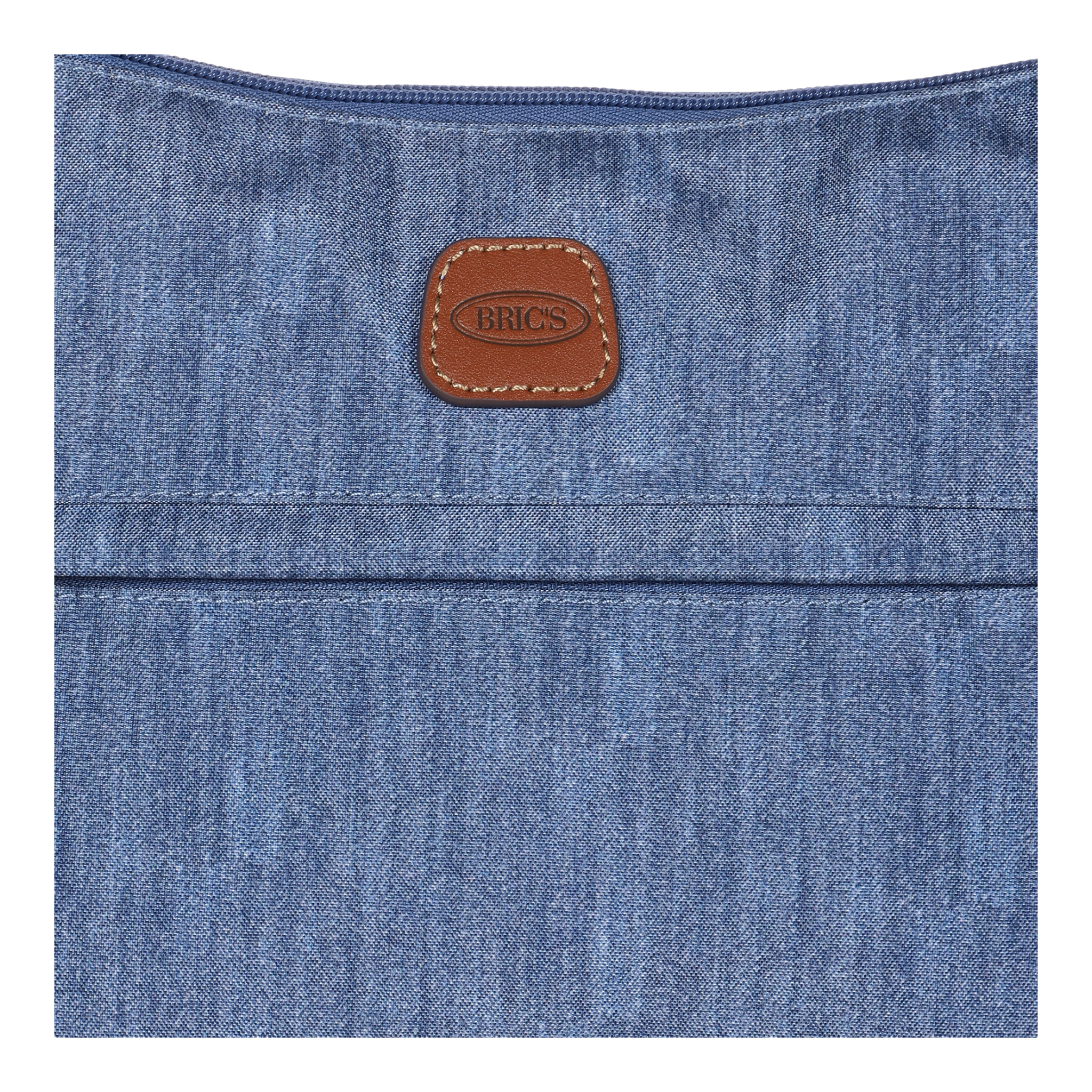 Nahaufnahme einer BRIC's Tasche aus Jeansstoff mit einem braunen Lederetikett im oberen Bereich.